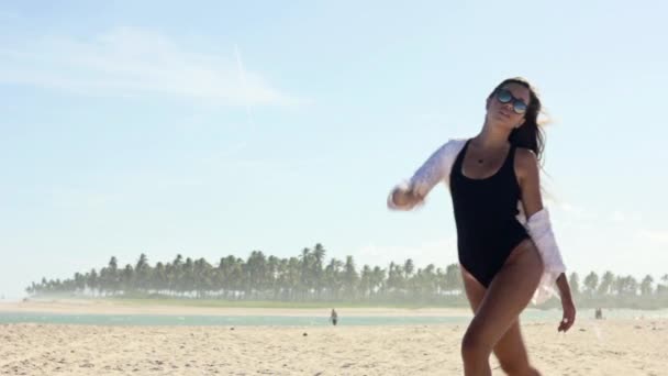 Jovem mulher caminhando na areia na praia — Vídeo de Stock