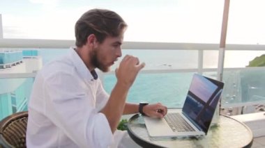 Kafede dizüstü bilgisayarda çalışan bir işadamı.
