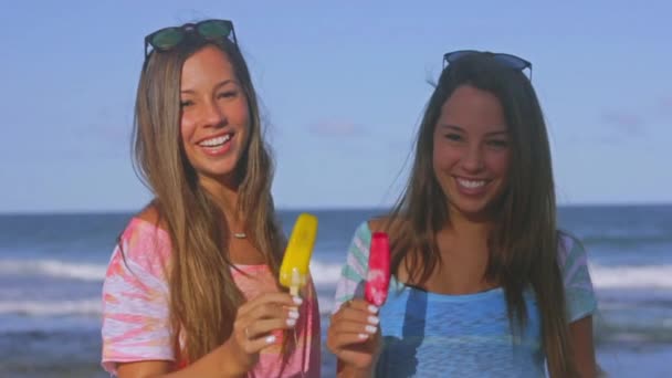 Tweelingzusjes met het smelten van ijslollys — Stockvideo