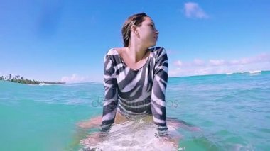 Sörf sörf tahtası üzerine oturan kız