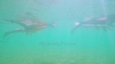 Kızlar sörf sörf tahtaları üzerinde yalan