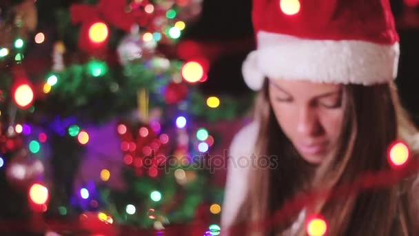 Женщина разворачивает рождественский подарок — стоковое видео