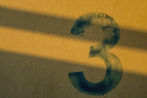 Numer 3 na ścianie w cieniu światła — Zdjęcie stockowe