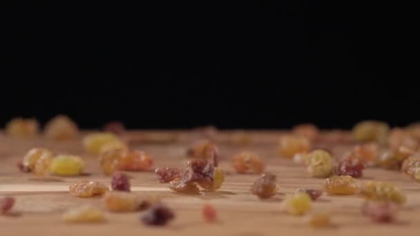 Raisins che cadono su un tagliere su uno sfondo nero — Video Stock