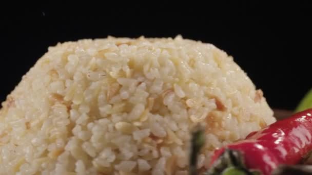 Närbild av ris och peppar på en svart bakgrund — Stockvideo