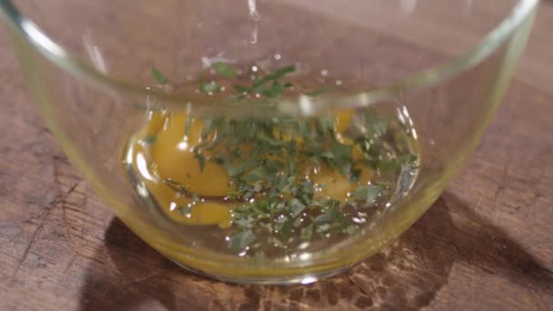 Adding greens to the bowl with eggs — Stock Video