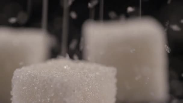 Nahaufnahme von drei Zuckerwürfeln auf schwarzem Hintergrund — Stockvideo