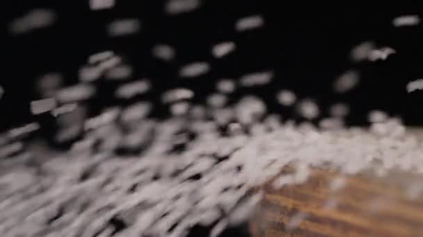 Detailní záběr na prkénku, solí, foukané přes okraj — Stock video