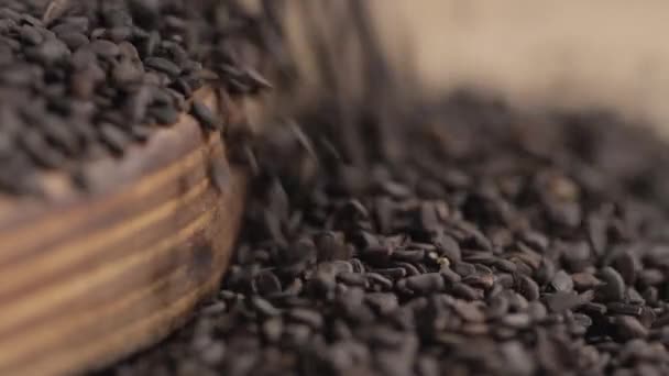 Close-up of cutting board, with black cumin blown off the edge — Stock Video