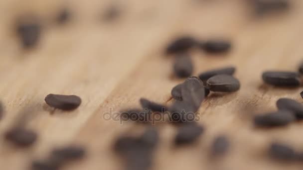 Närbild av korn av svart kummin faller på en tabell — Stockvideo