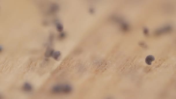 Close-up de especiarias caindo em uma placa de corte de madeira — Vídeo de Stock