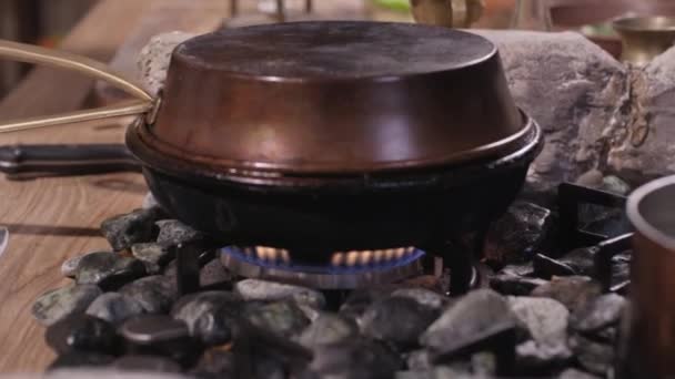М'ясо з маленькими сливами на сковороді на плиті — стокове відео