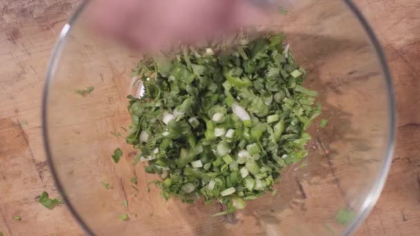 De cima para baixo de adicionar alho-porro para tigela com verdes — Vídeo de Stock