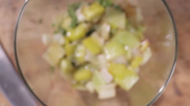 Von oben nach unten eine Zitrone in eine Schüssel mit grünem Gemüse pressen — Stockvideo