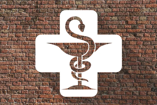 Pharmacy icon in a cross on brick wall background