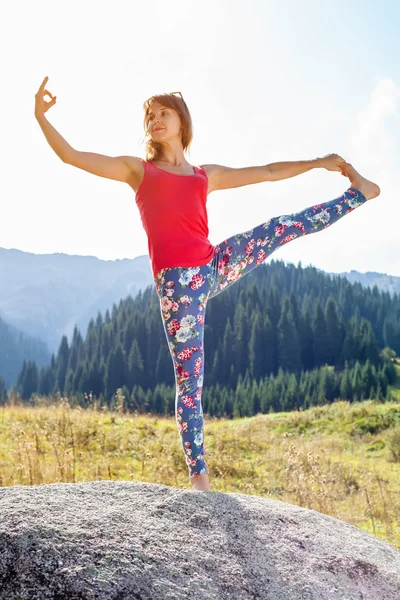 Młoda kobieta robi joga na skale — Zdjęcie stockowe