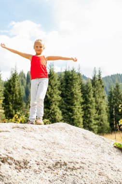 Kız arka planda büyük bir taş Dağları üzerinde ayakta