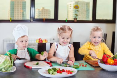 Üç sevimli çocuklar mutfakta bir salata hazırlanıyorlar
