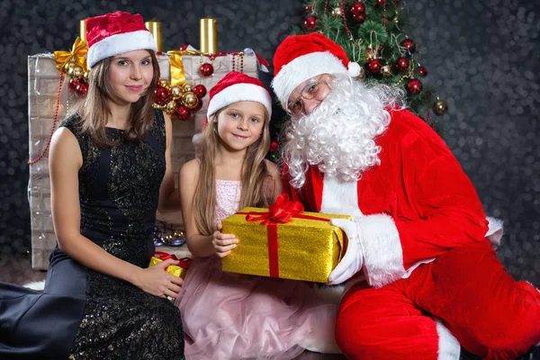 Jultomten och mor med ditt barn i en klänning. Christmas scener. — Stockfoto