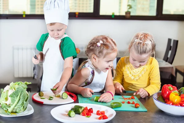 Üç sevimli çocuklar mutfakta bir salata hazırlanıyorlar