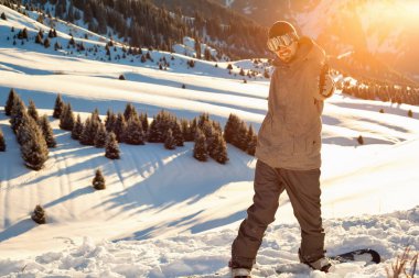 Snowboard kollarını kaldırdı dağın tepesinde duruyor