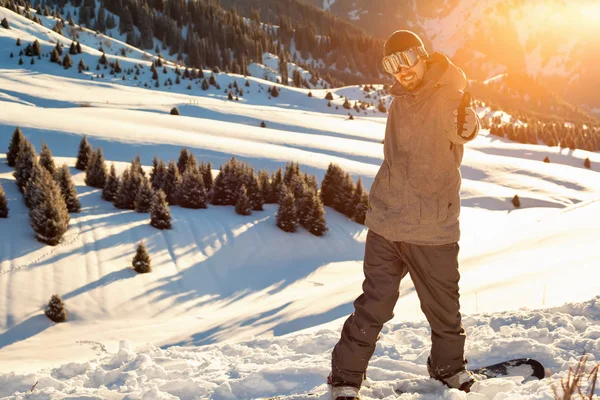 Сноубордист стоїть на вершині гори з піднятими руками — стокове фото