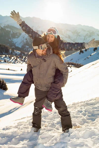 Souriant snowboarder tenant petite amie sur son dos — Photo