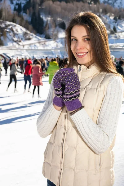 Csinos nő korcsolyázni télen kint, mosolygó arc. hegyek a háttérben — Stock Fotó