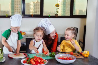Üç sevimli çocuklar mutfakta bir salata hazırlanıyorlar
