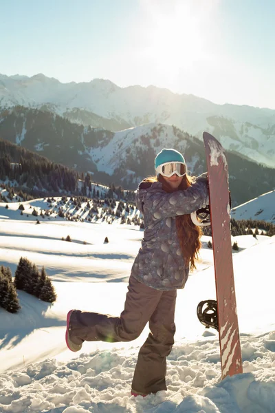 Fille snowboarder stands sommet de montagne avec snowboard dans les mains . — Photo