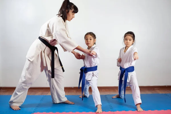 Treinador mulher mostrando arte marcial para crianças — Fotografia de Stock