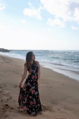 Kadın kumlu bir plaj boyunca yürür