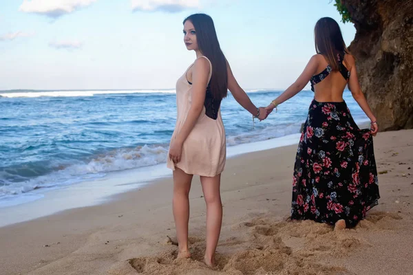 Deux filles posant sur la plage devant le rocher . — Photo
