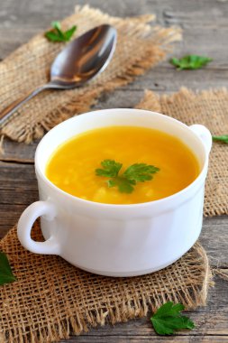 Patates, pirinç ve maydanoz ile balkabağı çorbası. Eski ahşap arka plan, kaşık, çuval bezi kapta basit balkabağı çorbası. Vejetaryen yemek. Rustik tarzı 