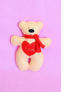 Bej renkli keçe ayı kırmızı kalp ile. Kelime aşk işlemeli. Sevgililer günü hediyesi