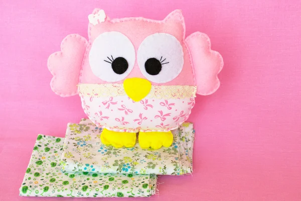 Pink felt owl on 2 pieces of fabric, handmade children's toy — Stock Photo, Image