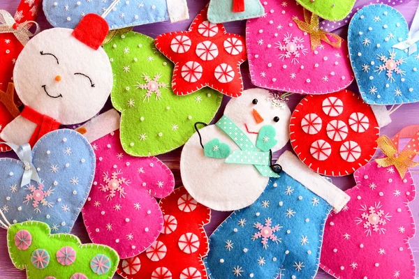 子供のクリスマスの背景。クリスマスのためのかわいい感じの装飾。クリスマスツリー、雪だるま、心、星を感じ、おもちゃをミトンします。混合ハンギングクリスマスの装飾は、赤緑の白青ピンクを死にます。季節の挨拶の背景。トップ表示 — ストック写真