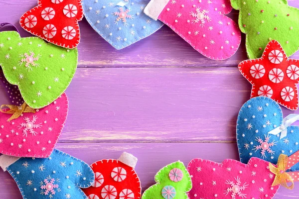 Different Christmas ornaments. Felt Christmas trees, mittens, hearts, stars on lilac wooden background with blank space for text. Winter festive background. Top view — ストック写真