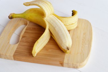 Beyaz ahşap zemin üzerinde açılan olgun muz 