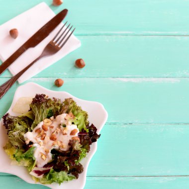 Salata karışımı bir plaka üzerine yoğurt ve fındık ile bırakır. Salata yaprakları radicchio, marul, buzdağı, friz pişirilir. Çatal, bıçak, peçete, metin için boş yer ahşap bir zemin üzerine ham fındık 