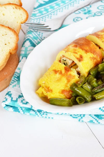 Omelette with cheese on a plate, fried green beans, bread, fork — Stock Photo, Image