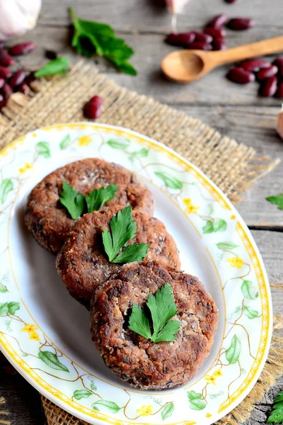 Barbunya, sarımsak ve baharat ile ev yapımı sebzeli hamburger. Kırmızı fasulye Burger tarifi. Pirzola yemek pişirmek için malzemeler. Eski ahşap arka plan. Vintage tarzı. Portre — Stok fotoğraf