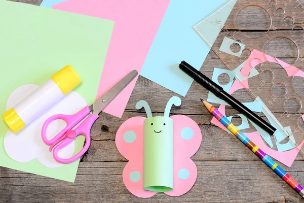 Schattig papier gesneden vlinder speelgoed, schaar, lijm stok, gekleurd papier set en restjes, liniaal, potlood op oude houten tafel. Ambachtelijke benodigdheden voor kinderen. Zomer kleuter creatieve papier kunst en ambachtelijke stijl project. Een close-up. Bovenaanzicht — Stockfoto