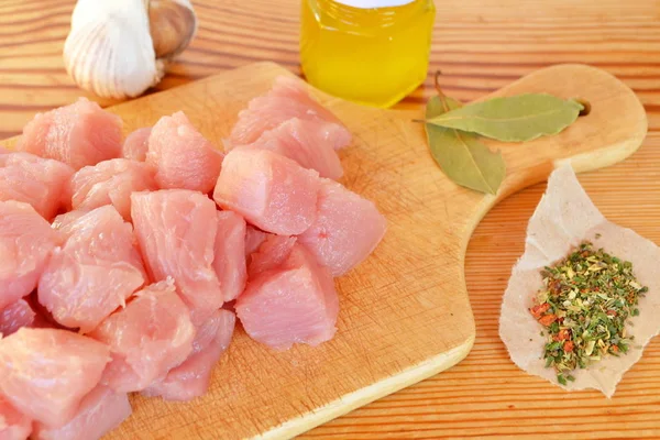 Tumpukan potongan daging sapi mentah di papan potong kayu, bawang putih, rempah-rempah, minyak zaitun — Stok Foto