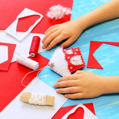 Çocuk bir keçe yılbaşı ağacı ev dekorasyon yapılan. Çocuk Noel ev dekorasyonu göster. Araç ve Gereçleri dikiş el sanatları için. Kolay kış el yapımı DIY çocuklar için. Mavi ahşap arka plan 