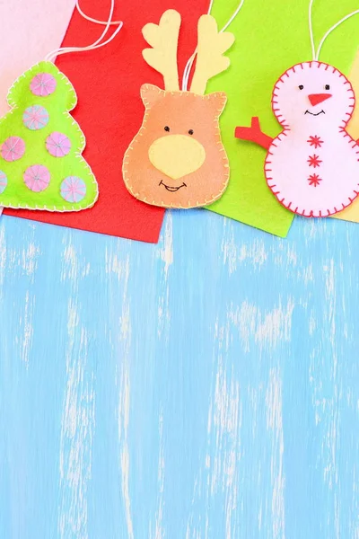 Christmas tree decorations. Funny felt reindeer head, Christmas tree, snowman decorations, flat felt pieces on a blue wooden background with copy space for text. Kids Christmas background. Top view — Stock Photo, Image