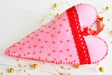 El yapımı pembe boncuk ve kırmızı dantel ile kalp hissettim. Sevgililer günü sembolü. Sevgililer günü hediyesi