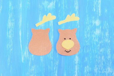 Noel Ren geyiği dekorasyon keçe dikiş. Adım. Keçe ayrıntılar üzerinde ahşap masa kesilmiş. Bir tarafta işlemeli siyah iplik gözler ve ağız, sarı iplik burun. Çocuklar için Noel kolay DIY. Üstten Görünüm 