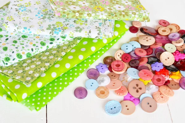 緑の花や水玉模様の布、円や花の形で明るい色のボタンの作品。縫製アクセサリーキット。仕事場の写真 — ストック写真