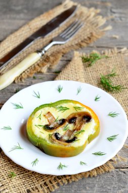 Bir tabak, çatal, bıçak üzerinde eski ahşap masa üzerinde ev doldurulmuş omlet. Dolmalık biber içinde kızarmış yağlı mantar ile lezzetli omlet. Kahvaltı için sağlıklı yumurta fikir. Rustik tarzı. Portre 